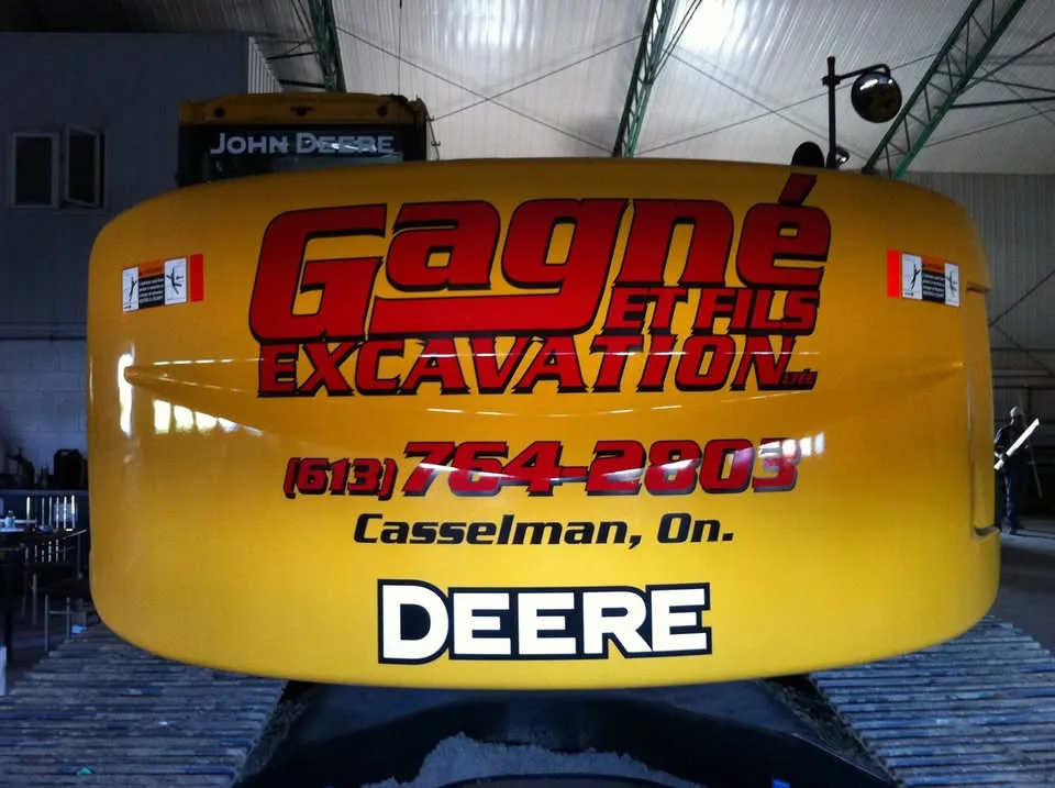 Une excavatrice de l'entreprise, lettrée « Gagné et Fils Excavation — Casselman »